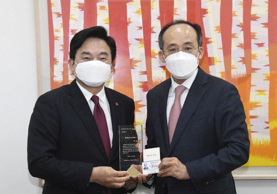 원희룡 제주도지사가 14일 서울 여의도 국회에서 추경호 국민의힘 원내수석부대표(오른쪽)에게 서울 4·3 특별법 개정과 예산 확보 노력에 대한 감사의 의미로 제주도 명예도민증을 수여하고 있다. 연합뉴스.